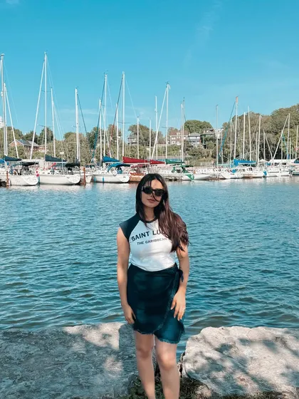 A full-length shot of my summer outfit at the marina, showing how I style a graphic tee and wrap skirt.