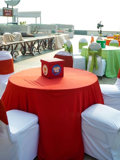 Outdoor seating with colorful tablecloths and chair covers for the sports-themed party.