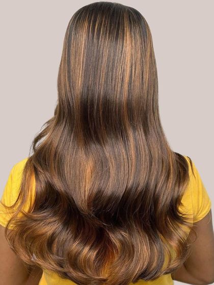 This is a perfect example of a Brown Sugar hair color, with rich caramel tones and subtle hints of golden honey. The back view shows how the balayage adds depth and dimension to long, healthy hair.
