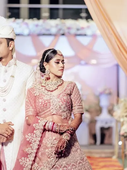 A more formal, stylized shot of Nupur and Chinmay at their wedding venue. This showcases their stunning outfits and the beautiful decor of their celebration.