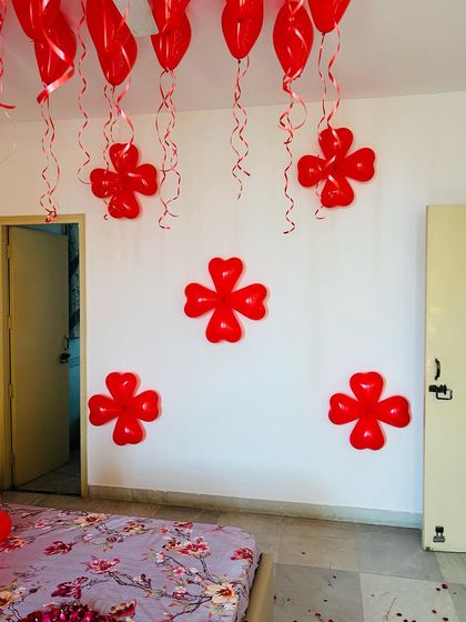 Simple and sweet room decor. We used red heart-shaped balloons to create flower-like patterns on the wall, adding a touch of love to the space.
