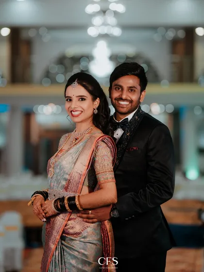 A happy and bright reception portrait. The couple's genuine smiles and the beautiful bokeh background showcase the joyful atmosphere of their celebration.