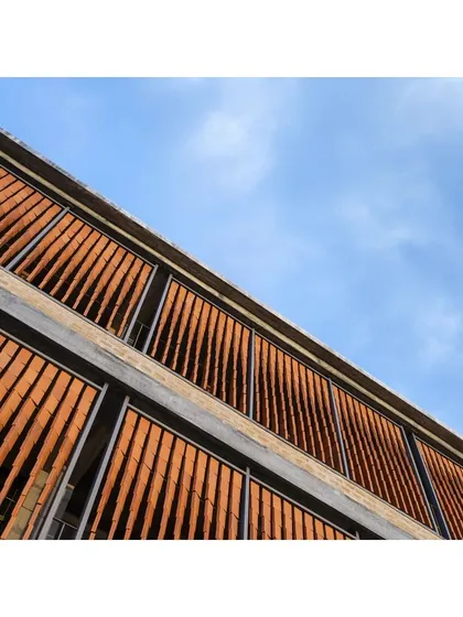 A close-up of the parametric terracotta jaali facade on the RSL Office. Each of the 1404 terracotta tiles is individually twisted to a specific angle, optimized through daylight analysis to provide glare-free, filtered light.