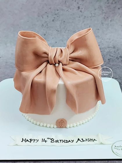 A beautiful gift box cake topped with a large, handcrafted bow. It's the perfect present for a 14th birthday.