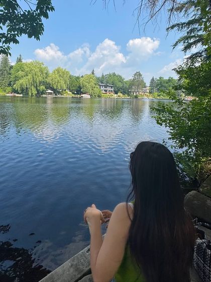 A peaceful moment looking out over the water. This type of thoughtful, scenic shot is great for creating a calm and reflective mood.