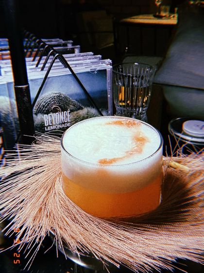 The 'Girls Just Wanna Have Fun' cocktail, a pop coded drink perfect for brunch. I styled this shot to capture its fun, girly vibe, placing it against the pampas grass and the Beyoncé 'Lemonade' album for context.