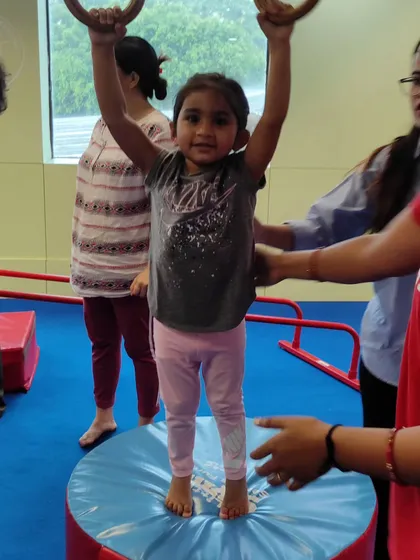 A proud moment for this little gymnast as she stands tall after practicing on the rings. This builds balance and confidence.