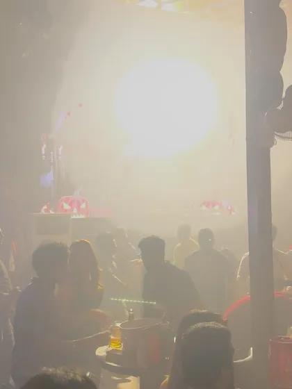 A smoky, atmospheric shot of the club, with the bright light from the DJ booth cutting through.