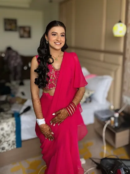 Dipped in hues of pink for her Mehndi. This client looks absolutely radiant in her pink saree, with soft makeup and beautiful curls.
