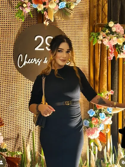 The birthday girl posing in front of a rustic chic backdrop. We used cane panels and colorful pastel floral arrangements to create a beautiful and textured photo opportunity for this 29th birthday.
