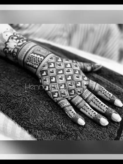 A black and white photo of a unique bridal design featuring a grid of hearts. This modern twist on the traditional jaali pattern is perfect for the romantic bride who wants a personal touch.