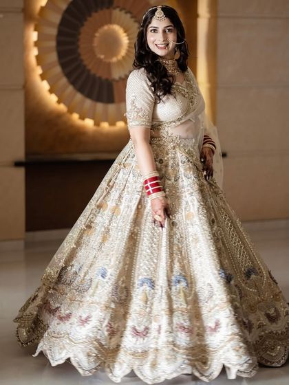 The complete bridal look, exuding grace and poise. The hairstyle is kept simple and elegant with soft waves to balance the magnificent outfit.