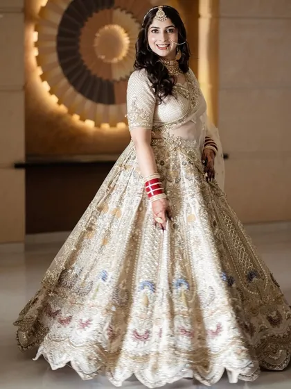 The complete bridal look, exuding grace and poise. The hairstyle is kept simple and elegant with soft waves to balance the magnificent outfit.