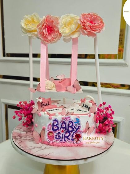 Swingin’ into the world with cuteness. This adorable swing cake was for a baby girl's arrival celebration, complete with pink flowers and butterflies.
