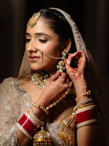 A candid moment of the bride getting ready. The soft, glowing makeup ensures she looks perfect in every shot, planned or spontaneous.