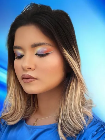 Eyes closed to show the sunset-inspired blend of colors on the eyelid, complete with a sharp white graphic liner detail.