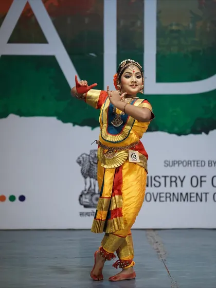 A student from the youth category who won 1st place. Her vibrant costume and confident pose capture the energy of her performance.
