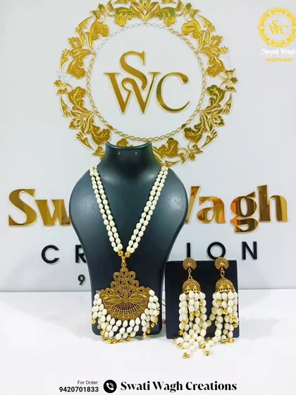 A new design that combines the beauty of floral jewellery with a traditional golden pendant. This elegant necklace and jhumka set can enhance any festive look.