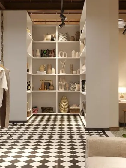 This view shows the transition from a lounge area to a retail display section. The consistent checkerboard flooring ties the different zones together, creating a cohesive flow throughout the store.