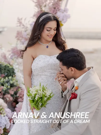 Arnav and Anushree looked straight out of a dream. This romantic moment, with the groom kissing his bride's hand, is made even more beautiful by the lush pastel floral decor surrounding them.