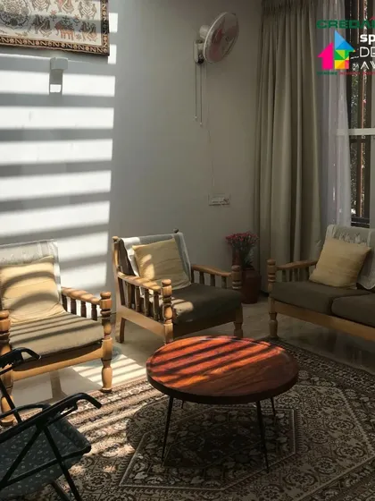 The living room is a calm oasis, where the stripes of light from the window blinds create a peaceful rhythm across the space.