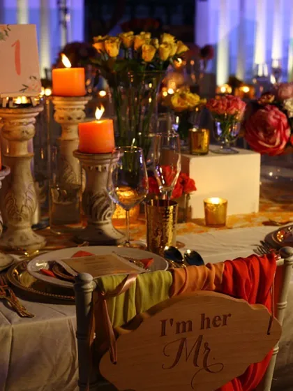 A beautifully decorated wedding table at dusk, with warm candlelight creating a romantic glow. We take pride in creating immersive guest experiences where the ambiance is as curated as the menu.