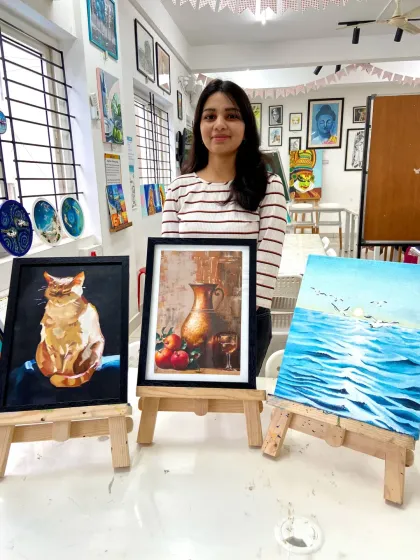Another happy graduate from our short-term painting course, displaying her beautiful artworks of a cat, a still life, and a seascape.
