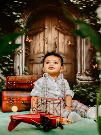 Ready for a grand adventure. This imaginative studio setup features vintage suitcases and a toy plane, perfect for capturing the spirit of a little explorer.