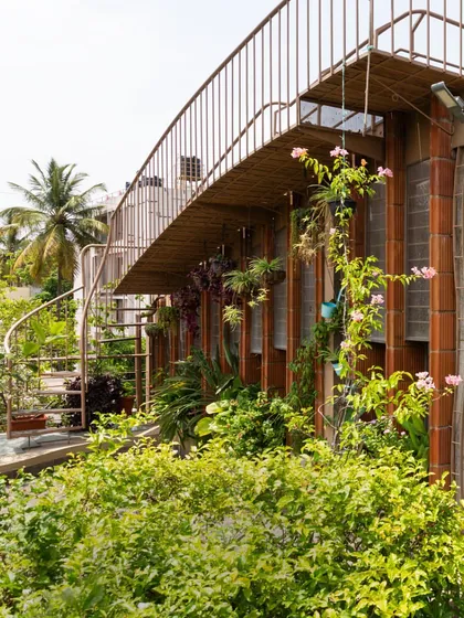 A terrace can be more than just a roof; it can be a garden retreat. Here, a spiral staircase leads up to a lush green space, blurring the line between the home and the sky. It’s a perfect example of how I integrate functional architecture with living, breathing nature.
