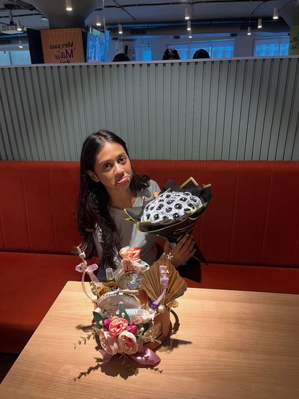A playful moment with the birthday girl and her custom gifts. The black and silver satin rose bouquet was a huge hit for her 21st birthday.