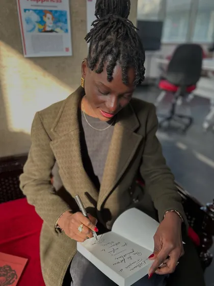 Author Douce Dibondo signing a copy of her book during her visit. We are committed to celebrating and amplifying queer voices and narratives.
