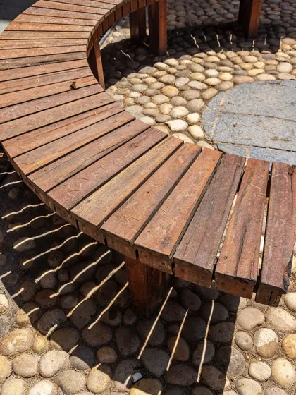 A close-up of the custom-made benches, showing the simple, robust construction and the beautiful texture of the reclaimed wood.