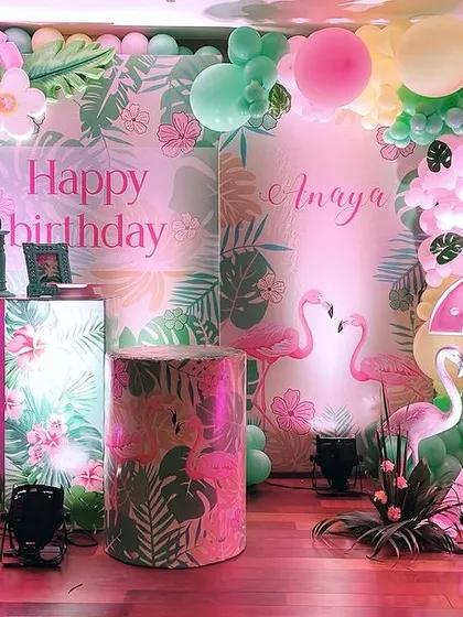 A 'Tropical Flamingo' theme for a second birthday, featuring a stunning backdrop with marquee lights, balloon garlands, and light-up flamingo props.