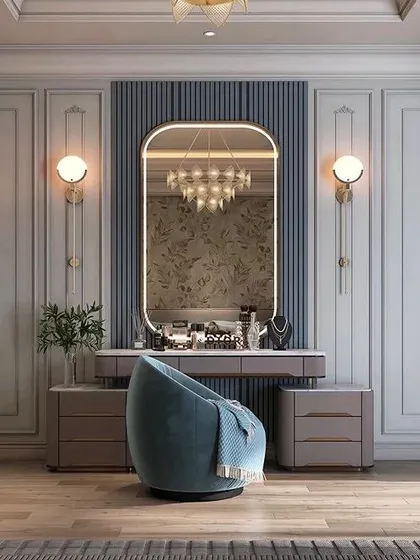 We seamlessly integrate functional dressing areas into our bedroom designs. This elegant vanity setup features classic wall molding, symmetrical sconce lighting, and a comfortable armchair, creating a dedicated space for your morning routine.
