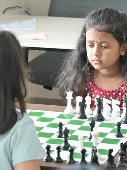 A young girl fully absorbed in her game, demonstrating the incredible focus that chess develops from an early age. Our beginner chess classes for kids are designed to be engaging and build foundational skills.