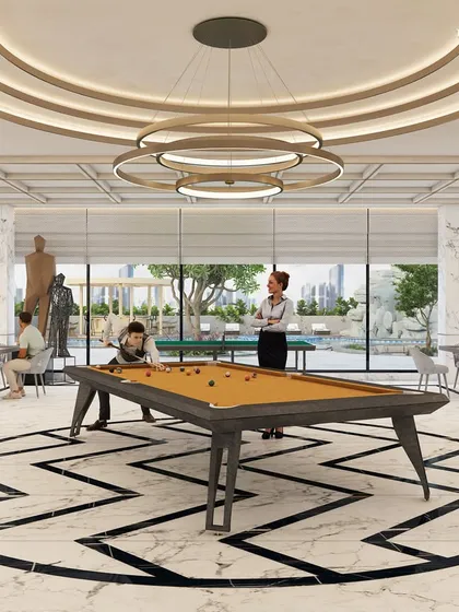 Another view of a games room, this one featuring a bold geometric pattern on the floor. The space includes a pool table and card tables, all under a coffered ceiling with modern circular light fixtures, creating a stylish environment for recreation.