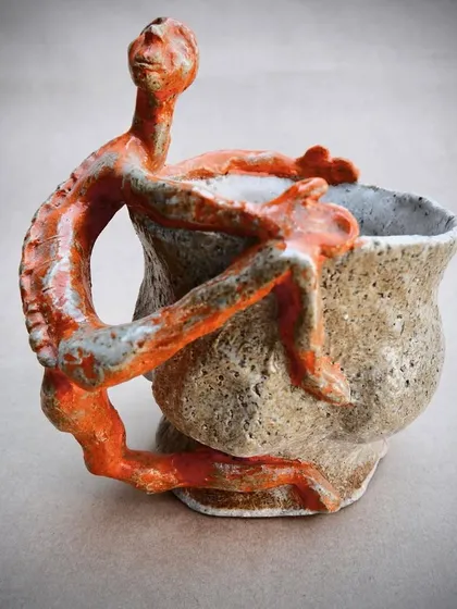 This piece explores our connection to the things we use daily. The hand-pinched cup features a figurative sculpture clinging to its side, a commentary on supervision and dependence.