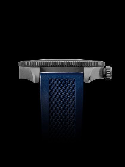 A clean, side-profile shot of the watch against a black background, highlighting its thickness and the texture of the strap.