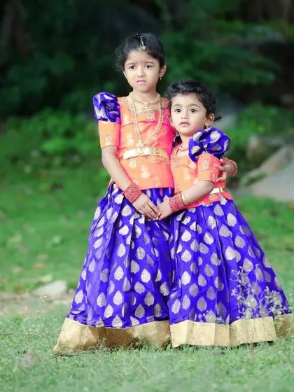 Sibling love! I created these coordinating Pattu Pavadai sets for two sisters. Using the same beautiful blue and gold brocade silk for the skirts, I designed unique blouses to match their individual styles.