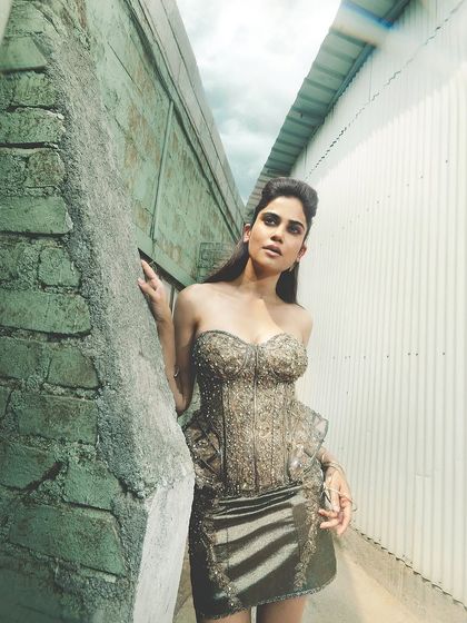 Another angle of the metallic editorial look. This shot shows the contrast between the raw, industrial background and the high-fashion styling and makeup.