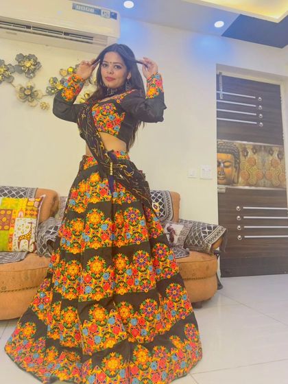 A model posing in the black floral embroidered lehenga, showing off the full outfit and its festive vibe.