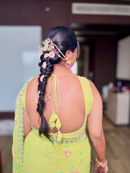 Another view of the intricate floral braid, showing the beautiful placement of fresh flowers that match her jewelry.
