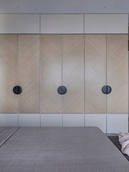 A full view of the bedroom in 'Aria Residence', showing the interplay between the red headboard, the patterned veneer on the wardrobes, and the grey marble flooring.