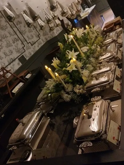 An angled view of the elegant silver buffet setup, emphasizing the beautiful reflections and sophisticated ambiance.