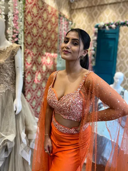 A close-up of Chandna Gowda wearing our orange Indo-Western piece, highlighting the detailed embroidery on the crop top.