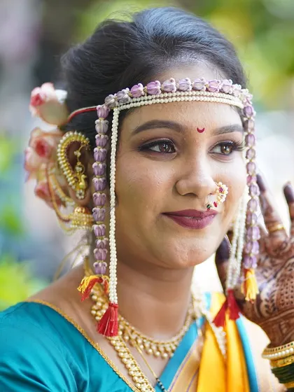 The beauty of a Maharashtrian bride lies in the details. This close-up highlights the flawless makeup, the intricate mundavalya, and the traditional nath, all coming together to create a divine look.