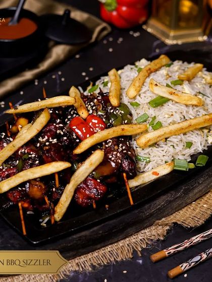 Savor the smoky goodness of our Chicken BBQ Sizzler. Juicy chicken skewers glazed with a zesty BBQ sauce are served on a sizzling bed of rice.