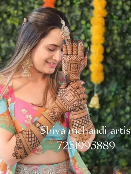 A happy bride showing off her custom mehendi. This design features personalized initials within a geometric pattern on the back of the hands, perfect for engagement ceremonies or the wedding day.
