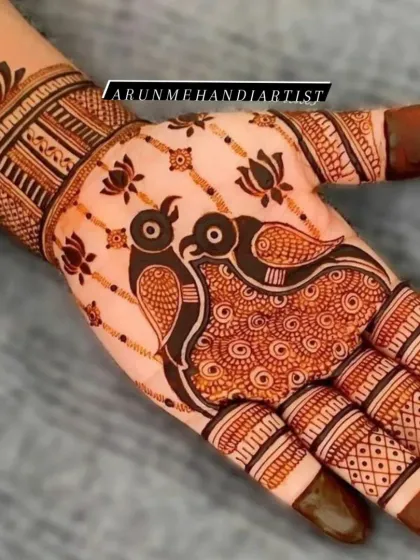A simple yet striking design featuring two love birds as the centerpiece of the palm. The surrounding lotus motifs and patterned fingers complete this elegant piece of henna art.