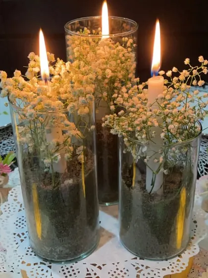 Light up your tables with a DIY floral centerpiece. There's no better way than combining candles and flowers to add elegance and warmth to your tablescape. Here, I've used glass cylinders, baby's breath, and tall candles.